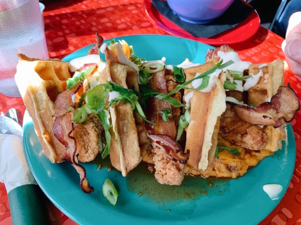 The Friendly Toast signature dishes Doughnut Stop Believin' (sandwich), Some Like It Hot Cakes, Chicken and Waffles, Signature Bloody Marys